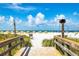 Scenic beach view from a wooden walkway, showcasing white sands and blue skies at 505 67Th Ave # 5, St Pete Beach, FL 33706