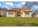 Back exterior view of a beautiful house with tile roof and lawn at 5226 Golf Links Blvd, Zephyrhills, FL 33541