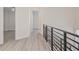 Bright hallway with modern metal railing and light flooring at 5226 Golf Links Blvd, Zephyrhills, FL 33541