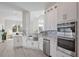 Modern kitchen with white cabinets, stainless steel appliances, and farmhouse sink at 5226 Golf Links Blvd, Zephyrhills, FL 33541