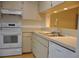 Bright kitchen features white appliances and ample cabinetry at 5265 E Bay Dr # 323, Clearwater, FL 33764