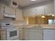 Galley kitchen, white appliances and cabinets at 5265 E Bay Dr # 323, Clearwater, FL 33764