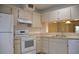 Galley kitchen, white appliances and cabinets at 5265 E Bay Dr # 323, Clearwater, FL 33764