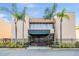 Exterior view of building entrance, featuring palm trees and a covered entryway at 5820 N Church Ave # 247, Tampa, FL 33614