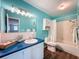 Bathroom with teal walls, white fixtures, and blue vanity at 6025 Shore S Blvd # 504, Gulfport, FL 33707