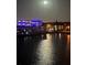 Night view of the waterfront, showing building lights and full moon at 6025 Shore S Blvd # 504, Gulfport, FL 33707