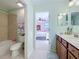 Bathroom featuring tile floors, single toilet, a bathtub and a view into the Primary bedroom at 6467 Willowshire Way, Bradenton, FL 34212