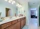 Well-lit bathroom features a double sink vanity with wood cabinets and decorative mermaid accents at 6467 Willowshire Way, Bradenton, FL 34212