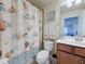 This bathroom has a shower with a tile surround, a vanity with storage, and a seashell themed shower curtain at 6467 Willowshire Way, Bradenton, FL 34212