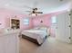 This pink bedroom features a ceiling fan, a charming dresser, and a sunny window overlooking the neighborhood at 6467 Willowshire Way, Bradenton, FL 34212