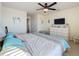 This bedroom features coastal themed decor and has a ceiling fan, beach artwork, and a dresser with a TV at 6467 Willowshire Way, Bradenton, FL 34212