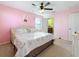 This pink bedroom has a Paris themed decor, a ceiling fan, and access to an ensuite bathroom at 6467 Willowshire Way, Bradenton, FL 34212