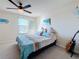 This bedroom features coastal themed decor and has a ceiling fan, beach artwork, and window at 6467 Willowshire Way, Bradenton, FL 34212