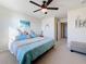 This bedroom features coastal themed decor and has a ceiling fan, beach artwork, and access to a bathroom at 6467 Willowshire Way, Bradenton, FL 34212