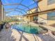 Exterior view of a screened-in pool with brick paver deck and outdoor dining area at 6467 Willowshire Way, Bradenton, FL 34212