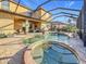 Screened-in pool and spa area featuring a stone paver deck at 6467 Willowshire Way, Bradenton, FL 34212