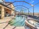 Screened-in pool and spa area featuring a stone paver deck and lush landscaping at 6467 Willowshire Way, Bradenton, FL 34212