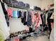 Walk-in closet features shelving with hanging clothes, shoes, and bins for storage at 6467 Willowshire Way, Bradenton, FL 34212