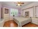 Main bedroom with hardwood floors, ceiling fan, and lavender walls at 6538 Green Acres Blvd, New Port Richey, FL 34655