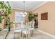 Bright dining room with a glass-top table, white chairs, and plants at 6538 Green Acres Blvd, New Port Richey, FL 34655