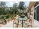 Relaxing patio featuring a table and chairs, surrounded by greenery at 6538 Green Acres Blvd, New Port Richey, FL 34655