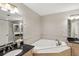 Bright bathroom featuring a corner soaking tub, dual vanities, and a separate glass enclosed shower at 684 Bayway Blvd, Clearwater, FL 33767