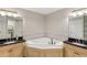 Bright bathroom featuring a soaking tub with dual vanities and large mirrors at 684 Bayway Blvd, Clearwater, FL 33767