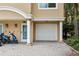 Close-up of a townhouse showing the garage, front door with columns, and paved driveway at 684 Bayway Blvd, Clearwater, FL 33767