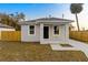 Newly constructed home with gray exterior, a covered porch, and a fenced yard at 701 E Wood St, Tampa, FL 33604