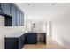 L-shaped kitchen with dark blue cabinets, white countertops, and a view into the living area at 701 E Wood St, Tampa, FL 33604