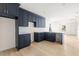 Modern kitchen featuring dark blue cabinetry, quartz countertops, and light wood flooring at 701 E Wood St, Tampa, FL 33604