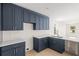 Modern kitchen with dark blue cabinetry, white countertops, and a kitchen island at 701 E Wood St, Tampa, FL 33604