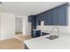 Modern kitchen with dark blue cabinets, white countertops, and stainless steel sink at 701 E Wood St, Tampa, FL 33604