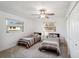 Cozy bedroom with two twin beds, ceiling fan, and natural light from the window at 7161 Fairway Bend Cir, Sarasota, FL 34243