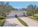 A shared driveway and attached garages sit in front of a charming home with manicured landscaping at 7161 Fairway Bend Cir, Sarasota, FL 34243