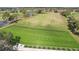 Birds eye view of driving range with golfers, putting range and lush green landscaping at 7161 Fairway Bend Cir, Sarasota, FL 34243