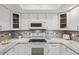 Bright kitchen featuring white cabinetry, stone countertops, and stainless steel appliances at 7161 Fairway Bend Cir, Sarasota, FL 34243