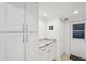 This mud room is decorated with white cabinets, granite countertops, and a door to the outside at 7161 Fairway Bend Cir, Sarasota, FL 34243