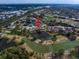 Elevated view showcases home's position within a golf community surrounded by ponds; indicated by red arrow at 7501 Cumberland Rd # 22, Seminole, FL 33777