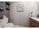 Charming half bathroom with wood-look vanity, floating shelves, and tasteful wall art at 7501 Cumberland Rd # 22, Seminole, FL 33777