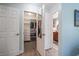 Hallway shot with view of walk-in closet and main bathroom featuring wood cabinets and tile floors at 7501 Cumberland Rd # 22, Seminole, FL 33777