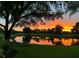 Tranquil view of a pond reflecting a vibrant sunset, enhancing the beauty of the surrounding greenery at 7501 Cumberland Rd # 22, Seminole, FL 33777