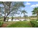 Scenic pond view featuring mature trees, green grass and blue skies at 7501 Cumberland Rd # 22, Seminole, FL 33777