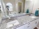 Bright bathroom features a double granite vanity, white cabinets, and a large mirror at 814 Tuscanny St, Brandon, FL 33511