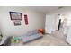 Playroom with neutral walls, gray sofa, rug, and toys, leading into the kitchen area at 814 Tuscanny St, Brandon, FL 33511