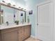 Bathroom featuring double sinks, a large mirror, and a linen closet at 868 Date Palm Ln, St Petersburg, FL 33707