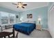 Charming bedroom with a cozy bed, soft blue bedding, and views through the windows at 868 Date Palm Ln, St Petersburg, FL 33707