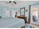 Bedroom features a wooden bed frame, ceiling fan, dresser, and access to an outdoor patio at 868 Date Palm Ln, St Petersburg, FL 33707