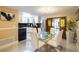 Bright dining area with glass table and white chairs, adjacent to a modern kitchen at 8807 Oak Cir, Tampa, FL 33615