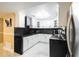 Well-lit kitchen featuring white cabinets, dark countertops, and stainless steel appliances at 8807 Oak Cir, Tampa, FL 33615